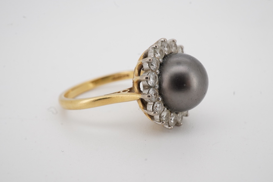 A modern 18ct gold and single stone Tahitian cultured pearl and diamond set circular cluster ring, size O, gross weight 7 grams.
